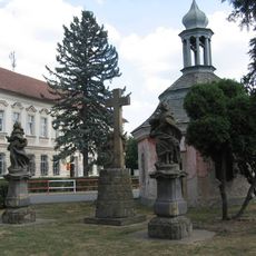Barokní kaple se souborem soch a křížem ve středu Bezna