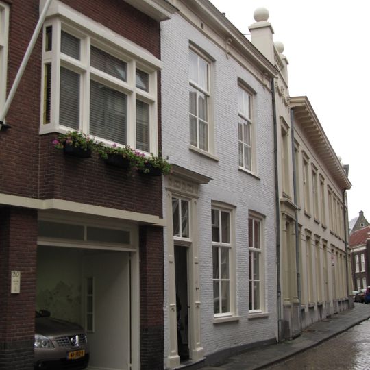 Huis met witgepleisterde eenvoudige empire lijstgevel en ingangsomlijsting, nog geheel woonhuisvorm