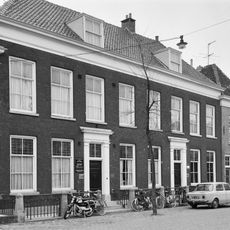 Linker gedeelte van een breed herenhuis, bestaande uit acht vensterassen, met verdieping en schilddak