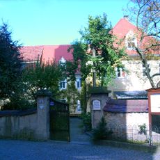 Pfarrhaus mit Einfriedungsmauer aus Bruchstein und zwei Eingangspfeilern Kirchplatz 1