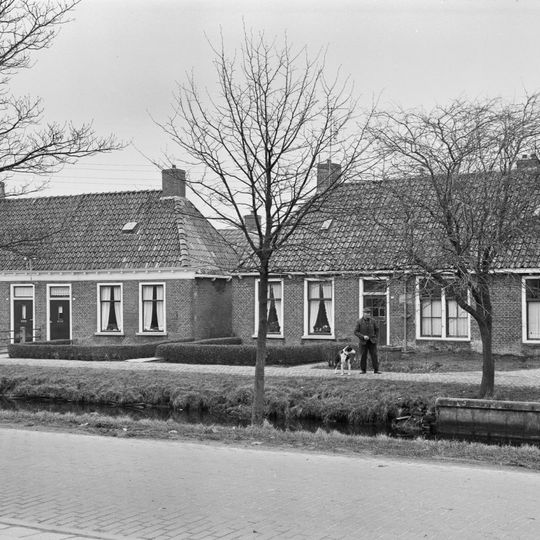 Pand met goot op klossen onder schilddak met hoekschoorstenen