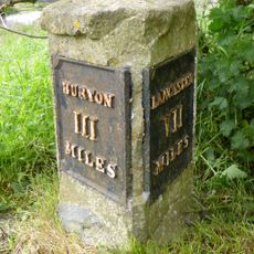 Milestone, Burton Road, Millhead, on bridge over River Keer, just before island for Truckhaven