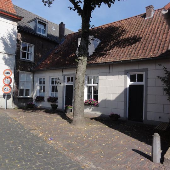 Eenvoudig witgepleisterd huis met rood zadeldak