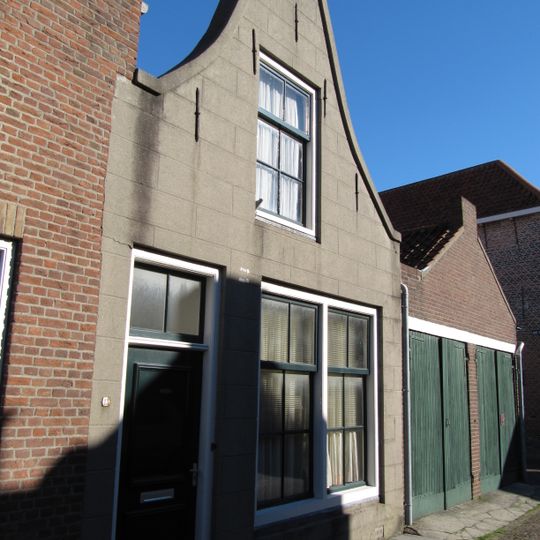 Huis met gepleisterde klokgevel