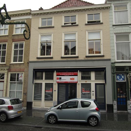 Huis met geelgeverfde lijstgevel en kroonlijst op kleine voluutvormige klossen, schilddak