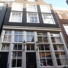 Pand met tot puntgevel gewijzigde trapgevel met houten pui