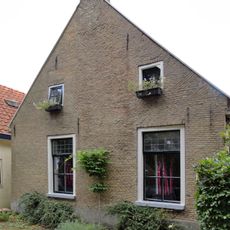 Kop-rompboerderij met topschoorsteen met bord