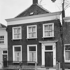 Pand met verdieping en schilddak, waarop schoorsteen met smeedijzeren sierbekroning