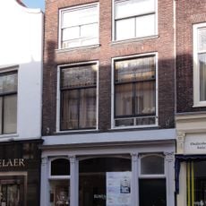 Pand met lijstgevel voor huis van parterre en twee verdiepingen. Geprofileerde, hardstenen vensterdorpels, drie consoles (Lod.XVI) onder de lijst. Ramen en pui modern