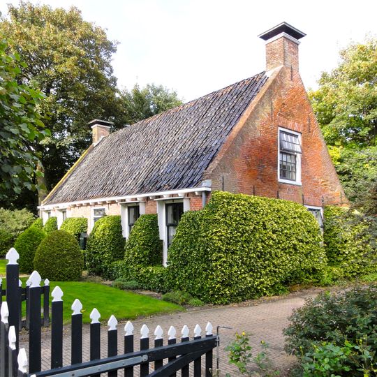 Woning onder zadeldak tussen topgevels met zesruitsvensters en tweelichtskozijnen in de toppen
