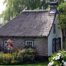Kleine boerderij onder zadeldak met gepleisterde punt-gevel, waarin vensters met oude kozijnen, luiken en oorspronkelijke roedenverdeling. Het boerderijtje is gerestaureerd