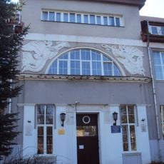 Главное здание с двумя рельефными фигурами «Гений с венком» и «Рог изобилия» (Калининград)