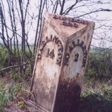 Milestone, in open country, tree on each side of road