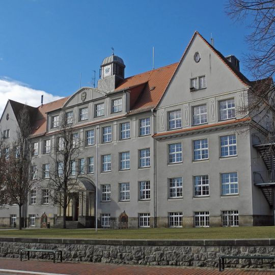 Schule mit gestalteter Freifläche aus Stützmauern, Treppenanlage und Allee Gezinge 12