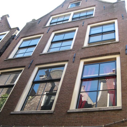 Huis met klokgevel onder rollagen en gebogen afdekking