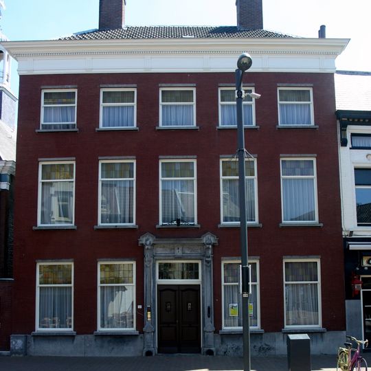 Herenhuis met roodgeverfde lijstgevel. Empire kroonlijst en hardstenen ingangspartij