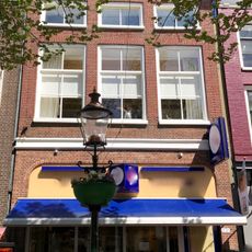 Pand met verhoogde gevel met lage zolderverdiepingvensters onder schilddak met topschoorsteen