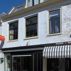 Pand met gepleisterde lijstgevel in topgevel eindigend