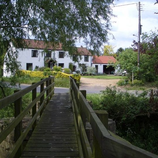 Footbridge at W end of village