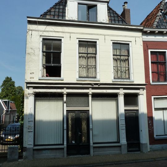 Pand met eenvoudige gepleisterde gevel en rechte kroonlijst