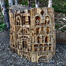 Tocón de eucalipto tallado a modo de escultura simulando un edificio o ciudad medieval abigarrada.