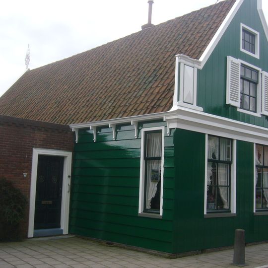 Houten huis, aan de straatzijde voorzien van een puntgevel met zijpilasters