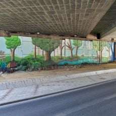 Mural de un paisaje forestal, con un río y montañas, bajo el viaducto donde se cruzan la avenida Europa con la autovía de circunvalación de Málaga.