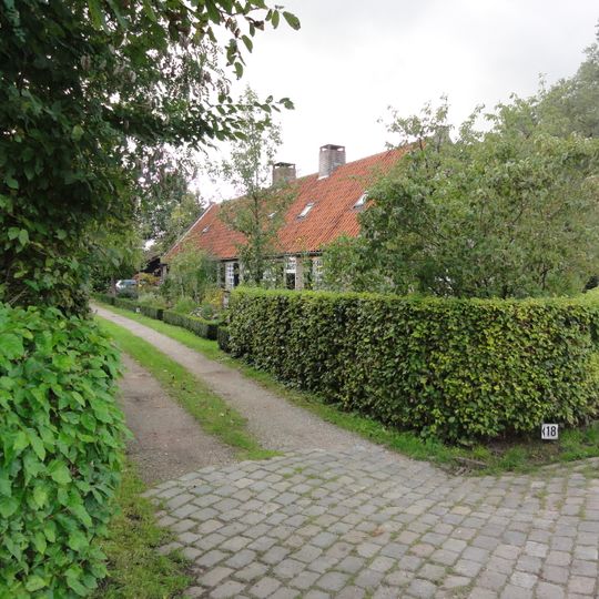 Reeks huisjes zonder verdieping onder een doorlopend zadeldak tussen puntgevels