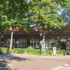Patronaatsgebouw en kerkhofmuur. Het patronaat, behoorde oorspronkelijk bij de R.K. parochie H. Naam van Jezus