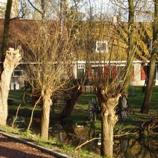 Boerderij, bestaande uit een parallel aan de dijk gebouwd woonhuis, onder een zadeldak met de daarnaast gelegen stal. In het woonhuis vensters met luiken en 12-ruitsschuiframen