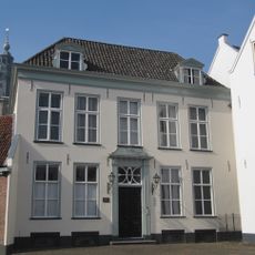 Huis onder hoog schilddak, waarin twee dakkapellen met driehoekige frontons