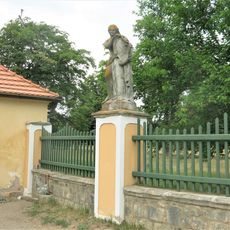 Alegorická socha Únor v ohradě zámecké zahrady ve Veltrusech