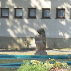 Socha dívky v areálu letního kina ve Slaném