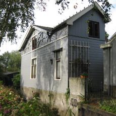Houten theehuis met ten dele versierde daklijst en openslaande deuren met luiken