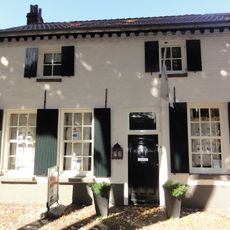 Huis met witgesausde lijstgevel en dwars zadeldak