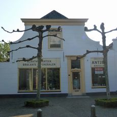 Huis met door lijst ingekorte gepleisterde topgevel