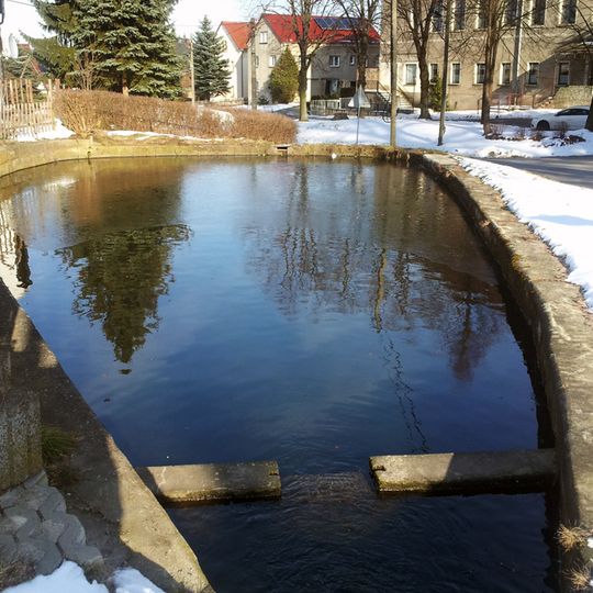 Kleiner Dorfteich, von Steinquadern eingefasst und von Grünfläche umgeben Großerkmannsdorfer Straße
