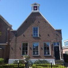 Pand met zolderverdieping, op hoge plint onder met pannen gedekt zadeldak