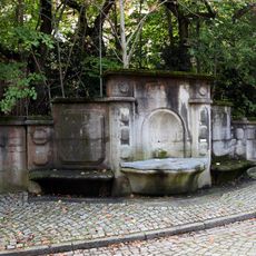 Wandbrunnen in Einfriedungsmauer mit Wasserbecken, Bronze-Figur in Nische und seitlich je einer flankierenden Steinbank (Einzeldenkmal zu ID-Nr. 09284584) Hufelandstraße 15 (bei)