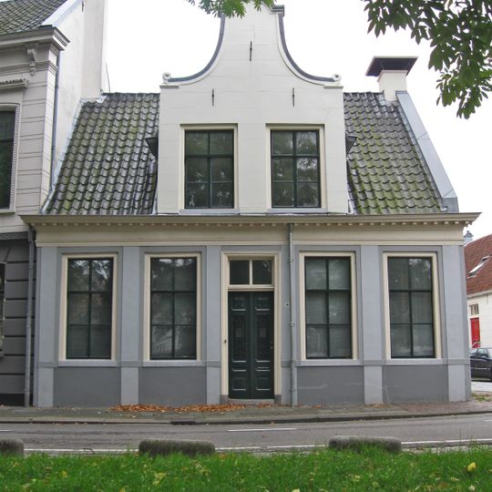 Witgepleisterd hoekpand met Vlaamse top