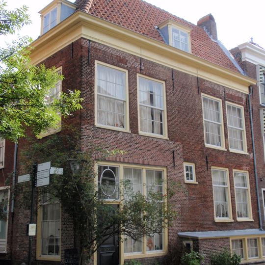 Hoekhuis met puntgevels. Ontlastingsbogen boven de oude vensters met winkelpui