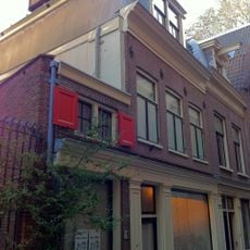 Huisje onder rechte lijsten plat dak met steile schilden