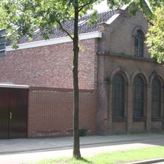 Gebouw, opgetrokken in 1883 tegen een ouder bouwdeel, oorspronkelijk fungerend als smederij