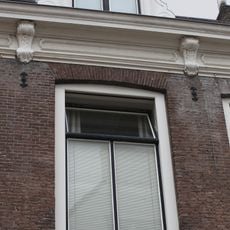 Patriciershuis ter breedte van vijf vensterassen onder schilddak met dakvenster. Kroonlijst met consoles Lod. XIV. Deurpartij met pilasters en Lod. XV-bladmotieven