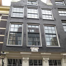 Huis met klokgevel waarin gesneden pui en gevelsteen en achtergevel onder rechte lijst met consoles