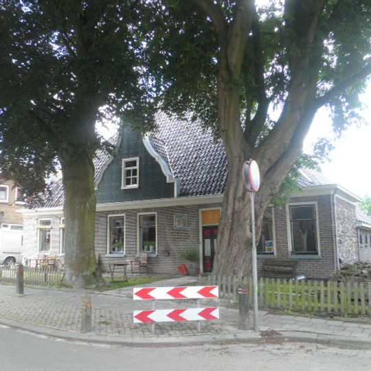 Stelphoeve met ingezwenkte houten topgevel boven de kroonlijst