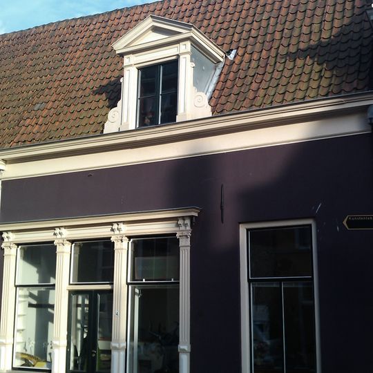 Onderkelderd huis met gepleisterde gevel, nok van zadeldak evenwijdig aan rooilijn