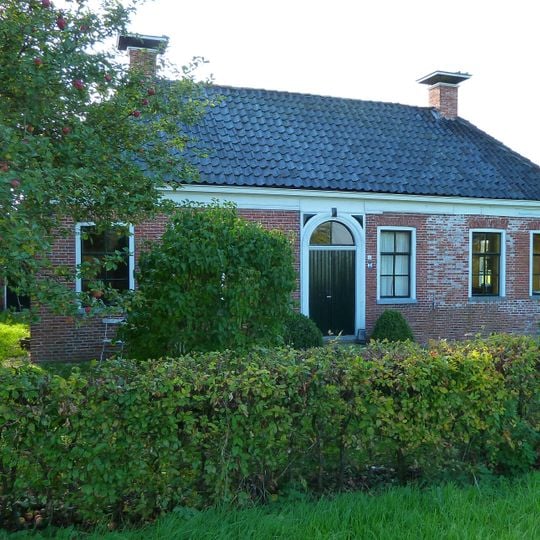 Landelijk pand onder laag schilddak met hoekschoorstenen