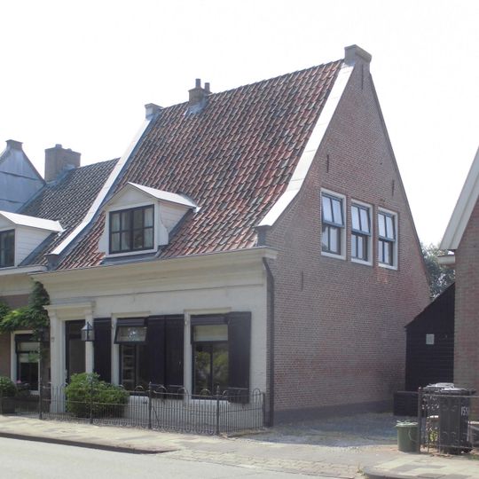 Pand zonder verdieping pand met lijstgevel aan de straatzijde voor de forse kap een dakkapel met driehoekig fronton en zijwangen