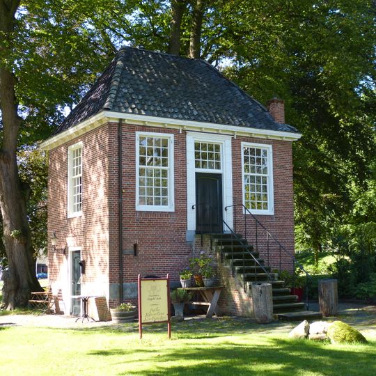 Engelse tuin. Rechthoekig gebouwtje met verhoogde begane grond en hoge stoep. Ingang met pilasteromlijsting